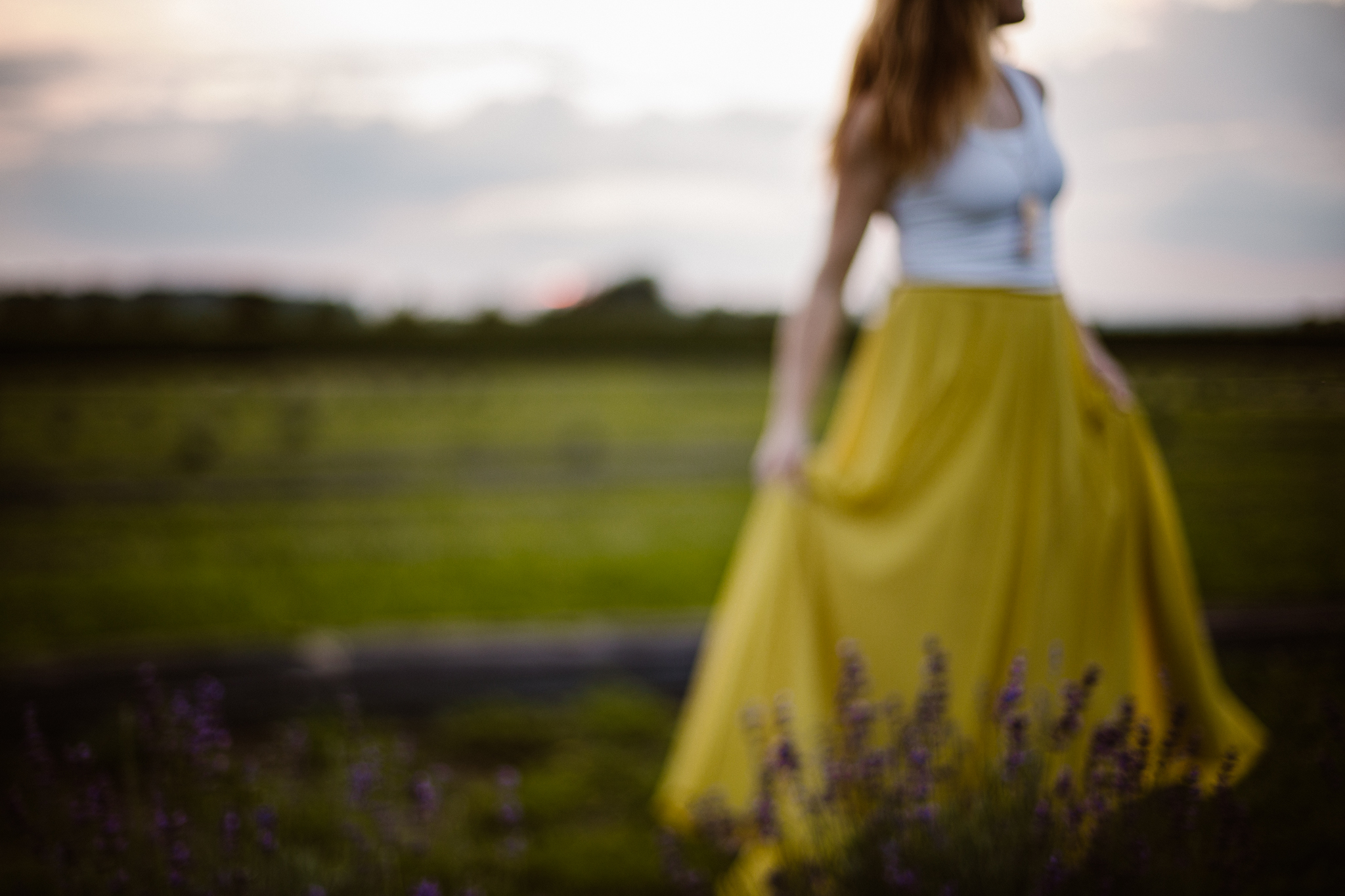 Red headed woman in yellow skirt at sunset in a lavender field.